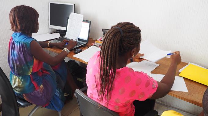 Two ladies analysing data at their computers